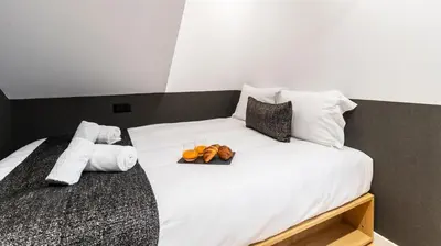 a white bed with a tray of fruit on it at Premium Duplex in Bonfim by LovelyStay in Porto