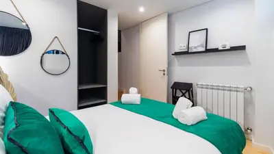 a bedroom with a large bed with green and white pillows at Premium 2BR Flat near Santa Catarina by LovelyStay in Porto