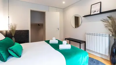 a bedroom with a large white bed with green pillows at Premium 2BR Flat near Santa Catarina by LovelyStay in Porto