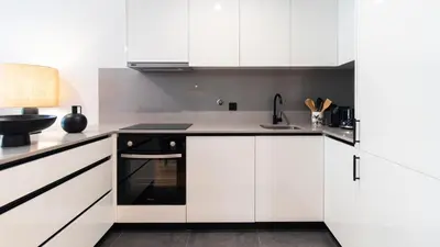 a kitchen with white cabinets and black appliances at Premium 2BR Flat near Santa Catarina by LovelyStay in Porto