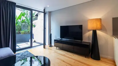 a living room with a tv and a large window at Premium 2BR Flat near Santa Catarina by LovelyStay in Porto