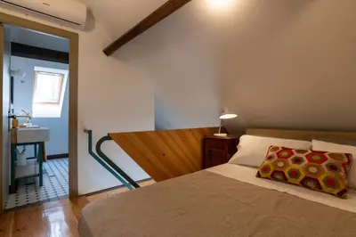 a bedroom with a bed and a bathroom with a sink at Victoria House in Porto