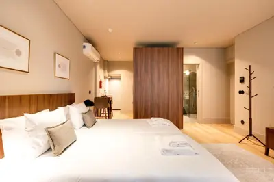 a bedroom with a large bed with white sheets at AVUS M Suites and Apartments by DA'HOME in Porto