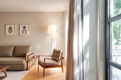 a living room with a couch and a chair and a window at AVUS M Suites and Apartments by DA'HOME in Porto