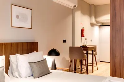 a hotel room with a bed and a table at AVUS M Suites and Apartments by DA'HOME in Porto