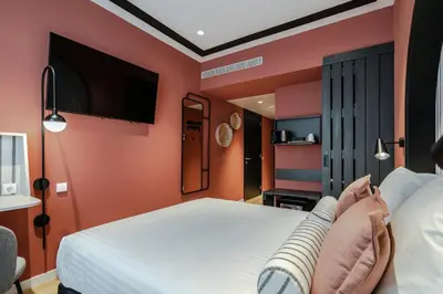 a hotel room with a bed and a flat screen tv at Vincci Bonjardim in Porto