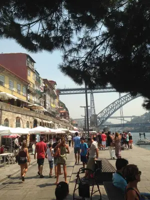 a crowd of people walking on a sidewalk near a bridge at Porto Chique AL 3 in Porto