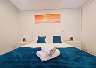 a bedroom with a large bed with towels on it at Alegria Stay in Porto