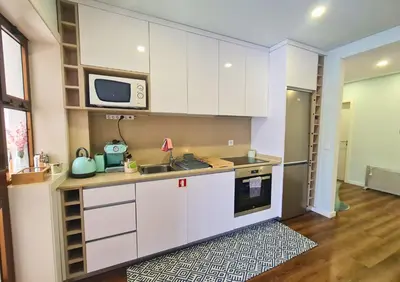 a kitchen with white cabinets and a microwave at Alegria Stay in Porto