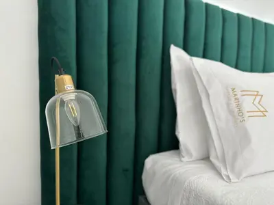 a lamp next to a bed with a green curtain at Marinho's Oporto Apartments in Porto