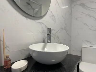 a bathroom with a white bowl sink and a mirror at Marinho's Oporto Apartments in Porto