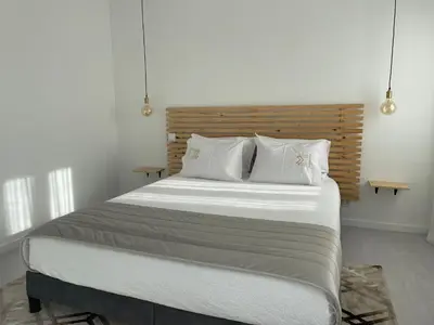 a bedroom with a large bed with white sheets and pillows at Marinho's Oporto Apartments in Porto