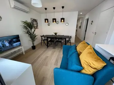 a living room with a blue couch and a dining room at HEART OF THE CITY 10 ! in Porto