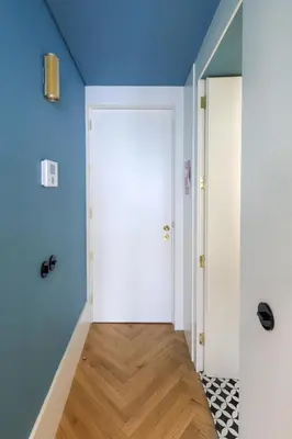 a hallway with a white door and blue walls at HM - Infante Riverside Apartment B in Porto