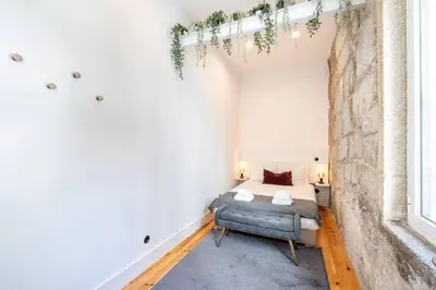 a small bedroom with a bed and a window at VIVA Aliados Downtown in Porto