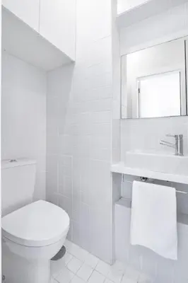 a white bathroom with a toilet and a sink at VIVA Marquês Studio in Porto