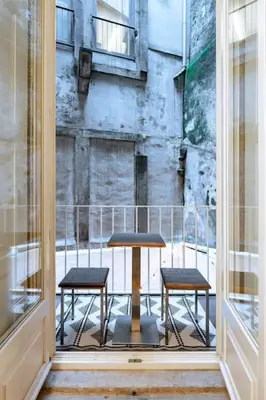 a balcony with a table and two stools in a window at VIVA Jolicoeur Porto in Porto