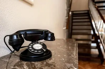 a black phone sitting on a table next to a staircase at VIVA Casa do Galo in Porto