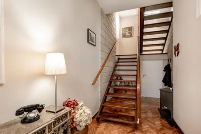a room with a staircase and a table with a lamp at VIVA Casa do Galo in Porto