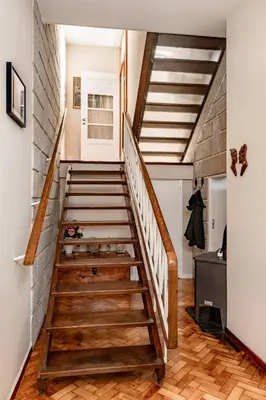 a staircase in a home with wooden floors and a brick wall at VIVA Casa do Galo in Porto