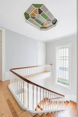 a staircase with a window and a stained glass chandelier at VIVA Arts Cozy Studio in Porto