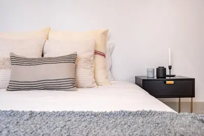 a bed with white sheets and pillows and a night stand at VIVA Formosa Flat in Porto