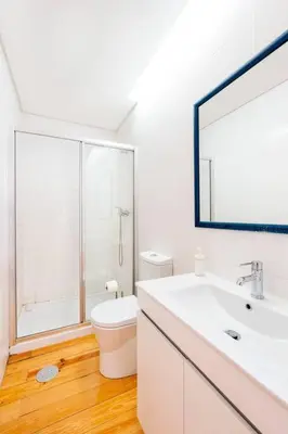 a bathroom with a sink and a toilet and a mirror at VIVA Mosaics Studio in Porto