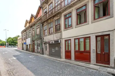 an empty street next to a building with red doors at VIVA Liberty 310 in Porto