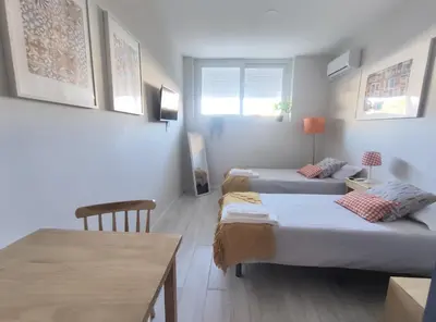 a small room with two beds and a table at Leote House - Studio 2 in Porto