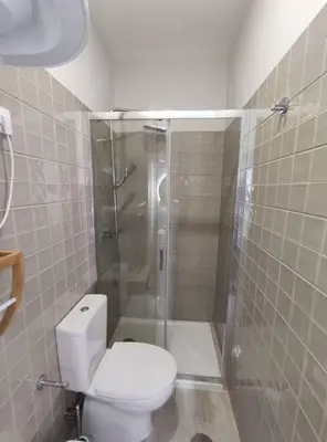 a bathroom with a white toilet and a shower at Leote House - Studio 2 in Porto