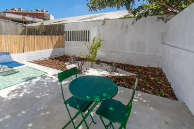 a green table and two chairs in a backyard at Leote House - Studio 3 in Porto