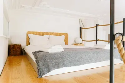 a bedroom with a bed with white walls and wooden floors at The Loft 333 in Porto