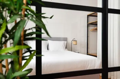 a bedroom with a white bed and a mirror at Rivoli Apartments in Porto