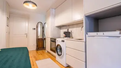 a kitchen with a washing machine and a washer at Taipas Tranquility: Cozy T0 by LovelyStay in Porto