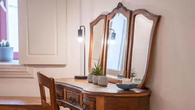 a wooden dressing table with a large mirror on it at Taipas Tranquility: Cozy T0 by LovelyStay in Porto