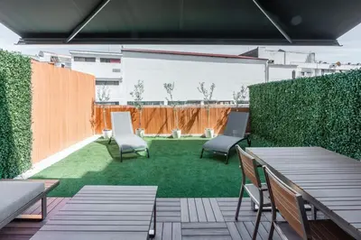 a patio with two chairs and a yard with grass at Patio in Central Porto in Porto