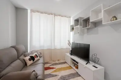 a living room with a couch and a flat screen tv at Great Location very Central Boavista in Porto