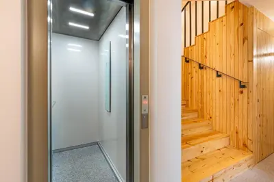 a glass door leading to a hallway with wooden stairs at Fontainhas Royal in Porto