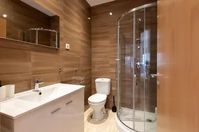 a bathroom with a toilet and a glass shower at GuestReady - Warm and Inviting flat with balcony in Porto