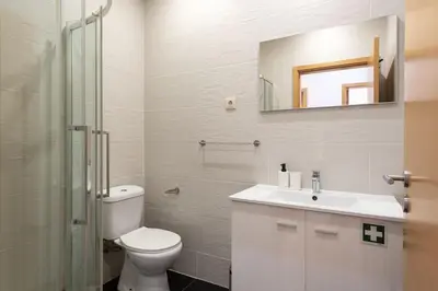 a bathroom with a toilet and a sink and a mirror at GuestReady - Warm and Inviting flat with balcony in Porto