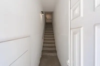 a hallway with a staircase with white walls and a stair case at GuestReady - Warm and Inviting flat with balcony in Porto