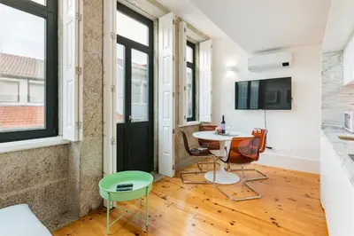 a living room with a table and chairs and windows at GuestReady - Stylish Haven near Porto Cathedral in Porto