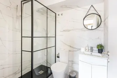 a bathroom with a shower and a toilet and a mirror at GuestReady - Caldeireiros Studios in Porto