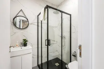 a bathroom with a shower with a glass door at GuestReady - Caldeireiros Studios in Porto