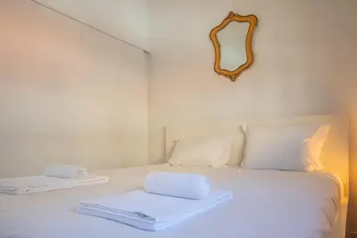 a white bed with two towels on top of it at Gardeny Porto in Porto