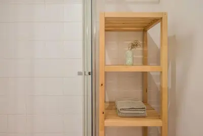 a wooden shelf in a bathroom with a shower at Gardeny Porto in Porto