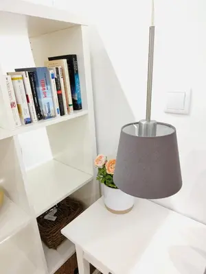 a lamp on a white table next to a book shelf at Apartment in the historic center of Porto in Porto