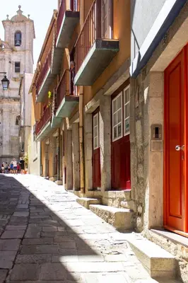 an empty street with red doors and a building at ORM Santana Apartment in Porto