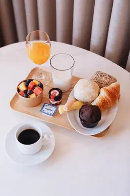 a tray of breakfast foods and a glass of orange juice at ORM Santana Apartment in Porto