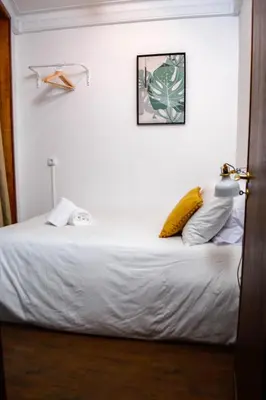 a bed in a room with a white wall at Travel & Live Marques Apartments in Porto
